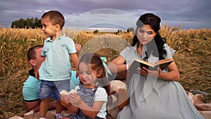 Picnic in a wheat field of a caucasian couple with two children in slowmo