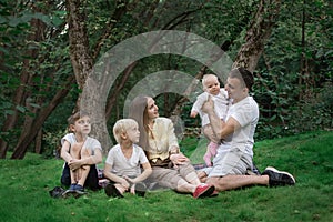 Picnic with whole family. Friendly loving family. Parents and three children