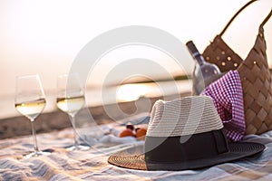 Picnic with wine on the beach by the sea. Romantic dinner at sunset. Copy space