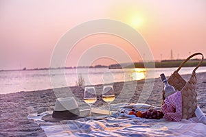 Picnic with wine on the beach by the sea. Romantic dinner at sunset. Copy space