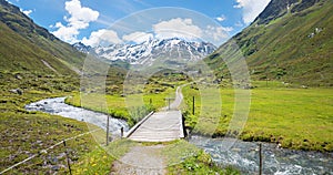 Pictorial Dischma valley, little creek and bridge, mountain view switzerland