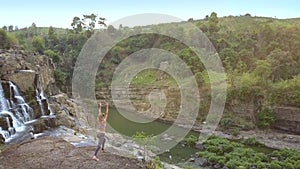 Pictorial landscape with waterfall and girl on rock