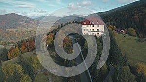 Pictorial modern hotel surrounded by brown autumn trees