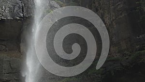 Pictorial waterfall surrounded by brown rocky cliffs