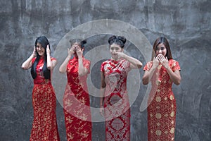 Picture of 4 cute Chinese girls wearing red cheongsams. Standing in various positions
