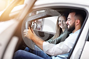 Adult couple choosing new car in showroom