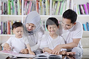 Asian family reading books in the library