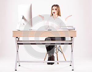 Picture of a beautiful businesswoman looks shocked while working with a computer on the desk