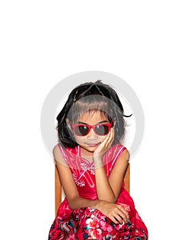 Picture of beautiful liitle girl in red dress wearing sun glasses sitting on chair