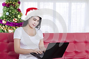 Beautiful woman with laptop and Santa hat