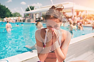 Picture from a Beautiful women in bikini with handkerchief. Sick female model has runny nose. girl makes a cure for the