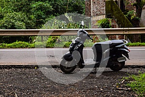 Picture of black color scooter parked at road side in India