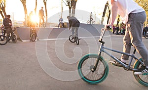 picture bmx riders at skate park at sunset background