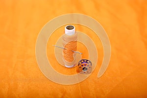 Picture of bobbins and sewing thread with needle
