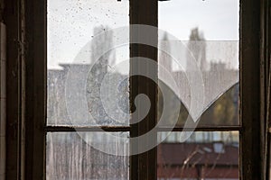 Selective blur on the shattered glass of a broken window with a wooden frame in an abandoned and vandalized private property house photo