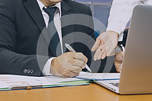 Business man hand signing on document with partner ,Asian women and men are doing business in the office, Business concept and