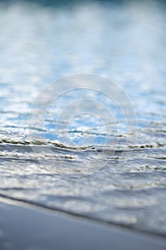 Pure water bokeh Clean water background with calm waves Blue sky reflection