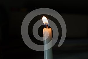 A Picture of a candle lighted in a dark room photo