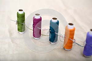 Picture of colored sewing thread and needle on the cloth