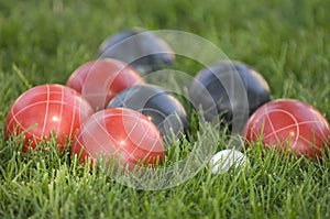 Picture of colourful bocce balls on the lawn under the sunlight with a blurry background