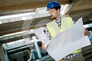 Picture of construction site engineer looking at plan