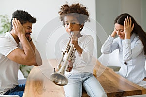 Picture of child making noise by playing trumpet photo