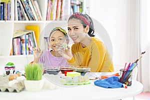 Child and mother showing a painted Easter egg