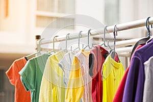 This picture depicts a colorful baby shirt hanging on an outdoor clothes rack.