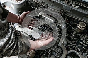 Picture of dirty hands of a guy above the engine