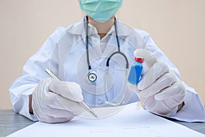The picture of doctor`s hand is holding a blue serum tube