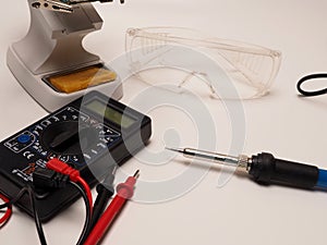 Picture of electronic repairing tools, consist of PCB holder stand, soldering iron, and protective eyeglass