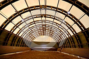 Picture of an empty indoor horse riding hall. Panoramic view in an indoor riding arena