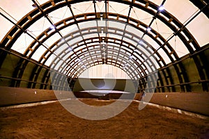 Picture of an empty indoor horse riding hall. Panoramic view in an indoor riding arena