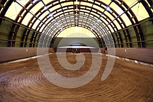 Picture of an empty indoor horse riding hall. Panoramic view in an indoor riding arena