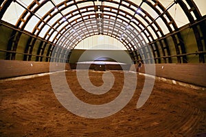 Picture of an empty indoor horse riding hall. Panoramic view in an indoor riding arena