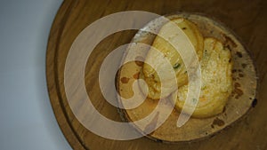 A picture of food, namely scallops that have been fried and placed on a wooden board and looks very delicious.