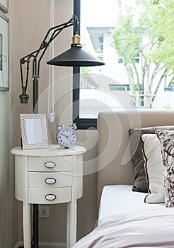 Picture frame and alarm clock on bedside table