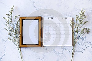 Picture frame and calendar and Caspia flower on marble background