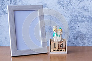 Picture frame and miniature Wedding couple on table. Valentine s day