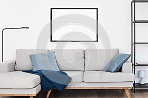 Picture frame mockup on white wall. Living room design. Empty white copy space for artwork showcase.