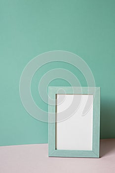 Picture frame on pink table. mint green wall background. copy space