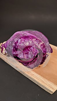 Picture of fresh red cabbage on the wooden chopping board isolated in black