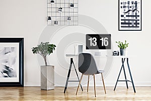 Picture gallery and a concrete planter in a simple home office interior for a freelancer professional with a computer screen mock-