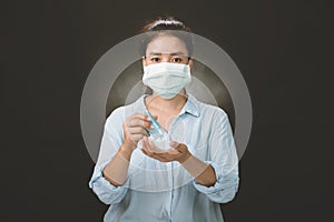 A picture of a girl in the studio wearing protection face mask against Resist infection coronavirus and Cleaning her hands with