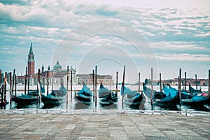 Picture with gondolas moored on Grand Canal near Saint Mark square, in Venice Italy with Church of San Giorgio Maggiore in the