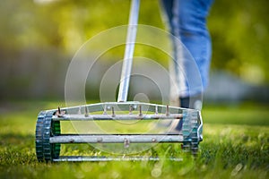 Picture of grass aerator on the green lawn photo