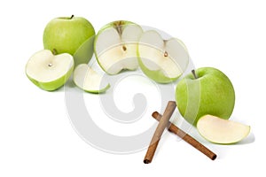 Picture of green apples and sticks of cinnamon on the white bac