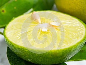 Picture of green citrus with leafs on a white isolated background