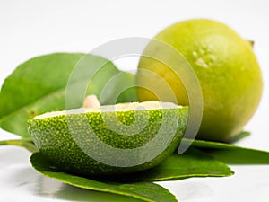 Picture of green citrus with leafs on a white isolated background