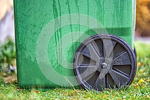Picture of green plastic garbage bin with black wheel